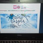 Slajd  plakatem promującym Dzień pająka wyświetlany na laptopie.