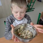 Uczeń trzyma miskę z wykonaną przez siebie sałatką