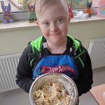 Uczeń trzyma miskę z wykonaną przez siebie sałatką.
