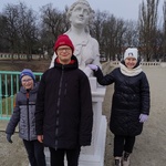 Trójka uczniów pozuje do zdjęcia przy rzeźbie w Pałacu Branickich.