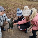 Trzy uczennice oglądają figurkę Widzimisia.
