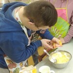 Uczeń wsypuje proszek do pieczenia do miski.