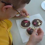 Uczeń ozdabia ryżowe ciastka.
