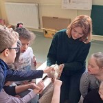 Uczniowie głaszczą kurę.
