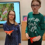 Uczennice z papierowymi motylami origami w dłoniach.