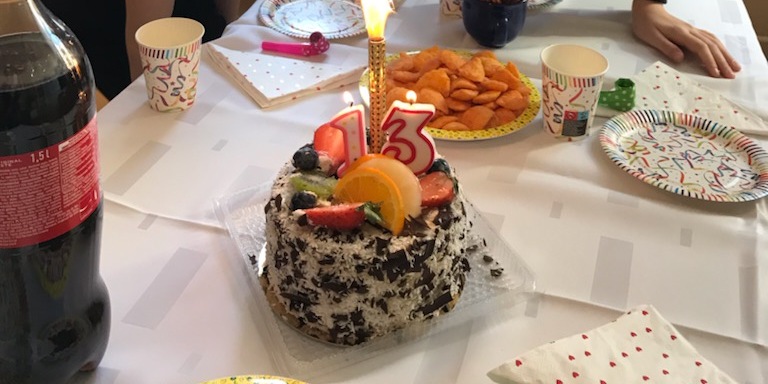 Jubilatka zdmuchuje świeczkę na torcie.