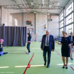 Pan prezydent Białegostoku Tadeusz Truskolaski i pani dyrektor Jolanta Woińska  na sali gimnastycznej. W tle nauczycielka i uczennica w trakcie zajęć.