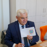 Pan prezydent Białegostoku Tadeusz Truskolaski pokazuje ozdobiony przez siebie piórnik szkolny.