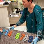 Nauczycielka trzyma tablicę z numerami.