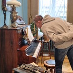 Uczeń stoi pochylony przed pianinem.
