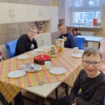 Grupa uczniów siedzi przy stole.