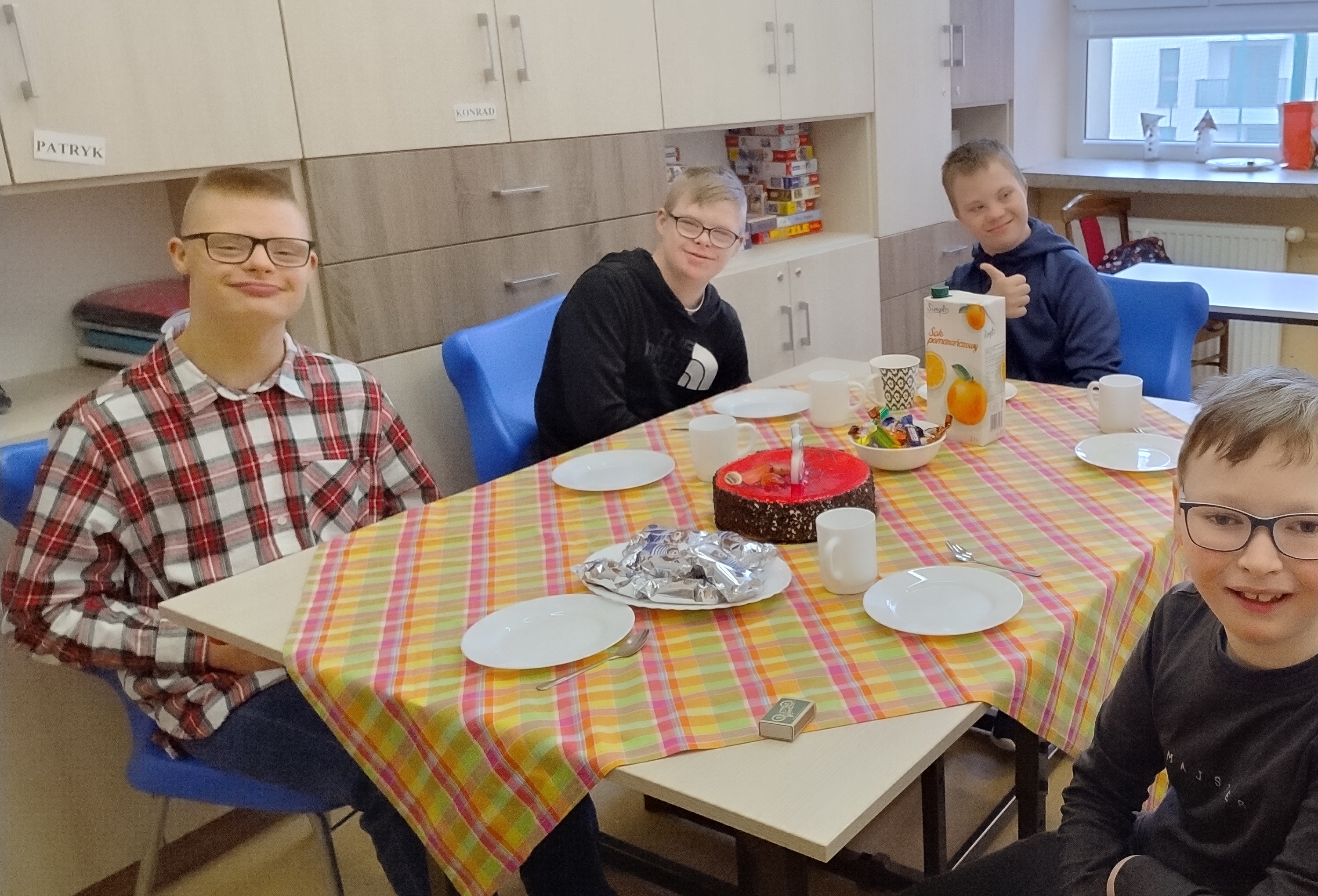 Grupa uczniów siedzi przy stole.