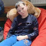 Uczeń siedzi na pufie.