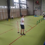 Uczniowie wykonują ćwiczenia na sali gimnastycznej.
