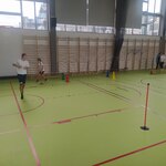 Dwoje uczniów biega na sali gimnastycznej.