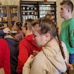 Grupa uczniów słucha opowieści edukatorki.