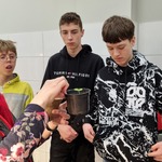 Pani pokazuje uczniom roślinę w doniczce/