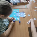 Uczennica siedzi przy stole i  uzupełnia tematyczną kartę pracy.
