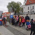 Grupa uczniów w przebraniach idzie w pochodzie.