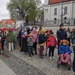 Grupa uczniów w przebraniach idzie w pochodzie.