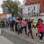 Grupa uczniów w przebraniach idzie w pochodzie.