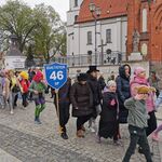 Grupa uczniów w przebraniach idzie w pochodzie.