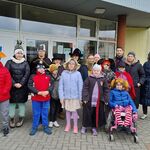Grupa uczniów i nauczycieli przed wejściem do szkoły.