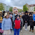 Grupa uczniów w przebraniach stoi  przed ratuszem.
