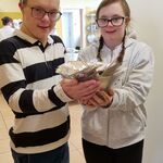 Uczeń i oczennica trzymają miskę z pamiątkami.