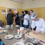 Grupa uczniów obserwuje zajęcia kulinarne.