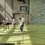 Grupa uczniów skacze przez skakankę którą trzymają nauczycielki.