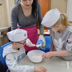 Uczniowie przyglądają się pani odmierzającej składnik.
