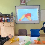 Uczniowie oglądają film instruktażowy o origami.