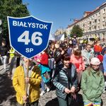 Na pierwszym planie uczeń z tarczą naszej szkoły. Za nim społeczność naszej szkoły biorąca udział w marszu.