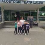 Grupa uczniów z nauczycielką stoją przed wejściem do Teatru Lalek