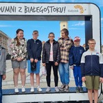 Grupa uczniów stoi w okienku z napisem 