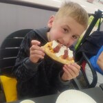 Chłopiec je pizzę.