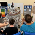 Uczniowie patrzą na nauczyciela przebranego za astronautę
