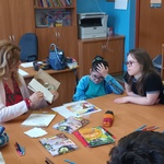 Autorka prezentuje książkę, uczniowie siedzą przy stole.
