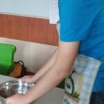 Uczeń stoi przy stole, przed nim stoi miska.