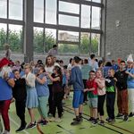 Sala gimnastyczna. Uczniowie i nauczyciele w trakcie zabawy w pociąg.