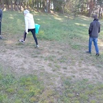 Uczniowie z workami na śmieci idą do lasu.