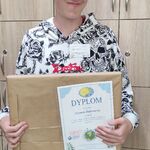 Uczeń z otrzymaną nagrodą i dyplomem.