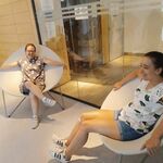 Dwie uczennice siedzą na okrągłych fotelach.