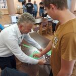 Uczeń losuje zadania konkursowe z torebki trzymanej przez organizatora.