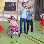 Grupa uczniów i nauczycielka śpiewają piosenkę.