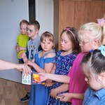 Pani pedagog wręcza upominki grupie uczniów.