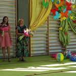Pani Dyrektor przemawia do mikrofonu, obok stoją rodzice i nauczycielka.