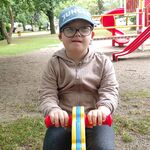 Uczeń buja się na koniku na placu zabaw.