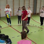 Uczestnicy półkolonii stoją w kole w trakcie Integracyjnej zabawy na sali gimnastycznej